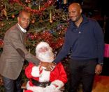 Claudy Siar, le Père Noël et Harry Roselmack lors du Noël pour Tous à la Palmeraie de Paris où 400 enfants ont reçu leurs cadeaux des mains du Père Noël le 7 décembre 2011