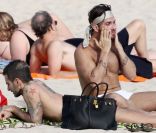 Le créateur Marc Jacobs, plongé dans ses lectures pendant que Lorenzo Martone se passe de la crème solaire. A Saint Barthélémy, le 28 décembre 2011.
