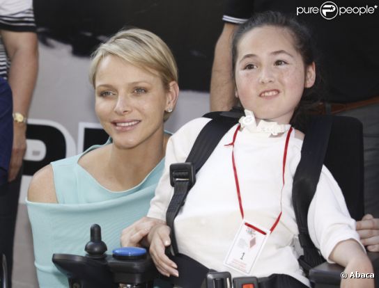 La princesse Charlene pose au côté d'une jeune fille handicapée rencontrée dans le paddock du Grand Prix de Monaco le 26 mai 2012