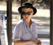 Michelle Williams en tenue relax twiste une robe légère en Libery avec un chapeau et des sandales noires.