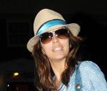 Eva Longoria, dans un look très cool, porte une blouse bleue, une ceinture en cuir,  et le sac 36 heuresen cuir vernis turquoise, le tout est signé Gerard Darel.