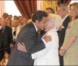 Nicolas Sarkozy embrasse Line Renaud après son sacre en tant que Grand Officier à l'Ordre National du Mérite, au Palais de l'Elysée, mardi 30 juin 2009