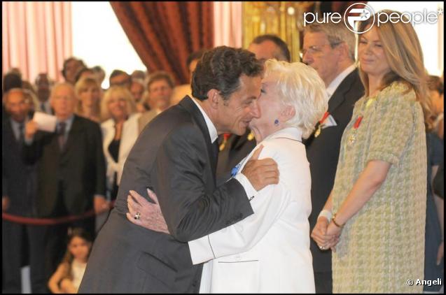 Nicolas Sarkozy embrasse Line Renaud après son sacre en tant que Grand Officier à l'Ordre National du Mérite, au Palais de l'Elysée, mardi 30 juin 2009