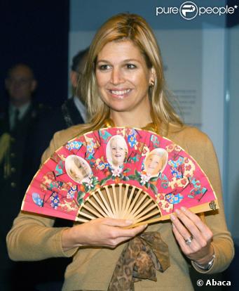 Maxima des Pays-Bas découvre un éventail avec des photos de ses trois fillettes, lors d'une exposition à Amsterdam, le 16 octobre 2009