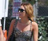 Miley Cyrus dans une petite robe léopard au top, qu'elle avait associé à une paire de boots en cuir, pour un look très réussi.