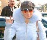 Gavroche, gilet court à fourrure, pantalon blanc et lunettes de soleil oranges... Jennifer Lopez cherche son style ! Heureusement depuis, elle a laissé au placard ses tenues douteuses ! Paris, 4 février 2002<br />