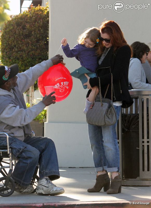 Alyson Hannigan et sa fille Satyana viennent en aide à un homme défavorisé à Los Angeles, le 17 janvier 2012.