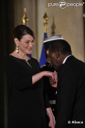 Carla Bruni-Sarkozy et Nicolas Sarkozy posent devant le seuil du palais présidentiel de l'Elysée avec Alassane  Ouattara, président ivoirien, et son épouse Dominique Ouattara, le 26 janvier 2012, à l'occasion d'un dîner d'Etat