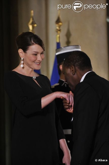 Carla Bruni-Sarkozy et Nicolas Sarkozy posent devant le seuil du palais présidentiel de l'Elysée avec Alassane  Ouattara, président ivoirien, et son épouse Dominique Ouattara, le 26 janvier 2012, à l'occasion d'un dîner d'Etat