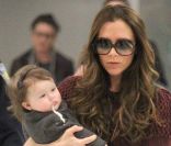 Victoria Beckham et Harper, qui a mal digéré son biberon, à leur arrivée à l'aéroport de New York, le 7 février 2012.
