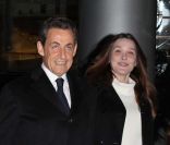 Nicolas Sarkozy, souriant et décidé, et Carla Bruni arrivent dans les locaux de TF1 juste avant sa déclaration au journal télévisé de 20 heures de Laurence Ferrari, à Paris, le 15 février 2012.