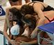 Camille Muffat, Charlotte Bonnet, Ophelie-Cyrielle Etienne et Coralie Balmy heureuses après avoir décroché le bronze olympique lors du relais 4x200 m nage libre lors des Jeux olympiques de Londres le 1er août 2012