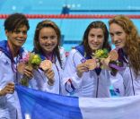 Camille Muffat, Charlotte Bonnet, Ophelie-Cyrielle Etienne et Coralie Balmy heureuses après avoir décroché le bronze olympique lors du relais 4x200 m nage libre lors des Jeux olympiques de Londres le 1er août 2012
