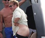 Elton John, entouré d'amis sur un yacht, montre ses fesses aux photographes au large de St-Tropez, le lundi 13 août 2012.