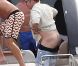 Elton John, entouré d'amis sur un yacht, montre ses fesses aux photographes au large de St-Tropez, le lundi 13 août 2012.