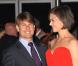 Fan absolue des Louboutins (les fameuses chaussures à la semelle rouge), Katie les accessoirise avec une sublime robe de soirée du même colori. Tom est trop sobre, à côté ! (fête des Beckham à LA - 22 juillet 2007) 