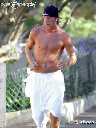 David Beckham en pleine séance de jogging. Torse imberbe et style épuré... (juillet 2003)