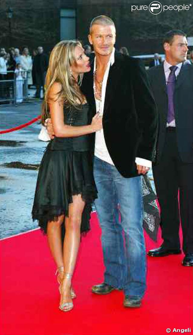 David et Vicky à une soirée de Londres.  Jean, et veste noir pour lui : le look simple mais qui fait toujours son effet. Et pour en rajouter au style, David n'a pas oublié la chemise TRES décolletée. (août 2004) 