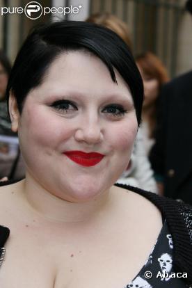 Beth Ditto radieuse à la sortie d'un défilé parisien. Elle ose les robes courtes et le maquillage flashy !