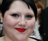 Beth Ditto radieuse à la sortie d'un défilé parisien. Elle ose les robes courtes et le maquillage flashy ! 