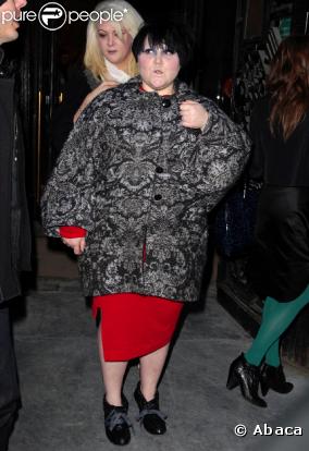 Beth Ditto à Paris au défilé Vivienne Westwood avec son manteau gris et sa robe rouge. Oui, elle aime se faire remarquer et c'est tant mieux !