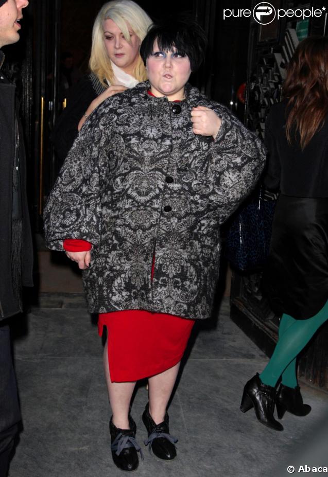 Beth Ditto à Paris au défilé Vivienne Westwood avec son manteau gris et sa robe rouge. Oui, elle aime se faire remarquer et c'est tant mieux ! 