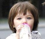 Un mois plus tard, en juillet 2007, changement de décor pour Suri la voyageuse, qui fait une balade dans les bras de Katie... à Berlin ! Et jamais sans son biberon... 
