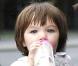 Un mois plus tard, en juillet 2007, changement de décor pour Suri la voyageuse, qui fait une balade dans les bras de Katie... à Berlin ! Et jamais sans son biberon...