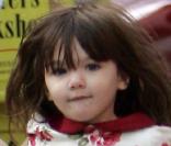 En octobre 2008, Suri, deux ans et demi, s'est laissé pousser les cheveux tout l'été et arbore une belle robe fleurie tandis qu'elle donne la main à son papa dans les rues de New-York. 