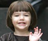 Elle a déjà tout d'une star... Suri gratifie les photographes d'un petit salut et d'un mignon sourire, en balade à New-York avec Katie, en novembre 2008. 