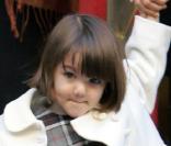 Suri est bien élégante en ce jour de février 2008... Sa maman Katie vient de l'emmener visiter une école de musique, et sur le chemin, elles font un peu de shopping, Suri se chargeant du sac. Elle grandit vite, cette petite ! 