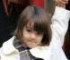 Suri est bien élégante en ce jour de février 2008... Sa maman Katie vient de l'emmener visiter une école de musique, et sur le chemin, elles font un peu de shopping, Suri se chargeant du sac. Elle grandit vite, cette petite !