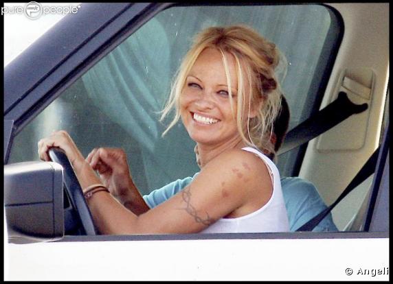 Pamela Anderson sans maquillage, toute souriante au volant de sa voiture le 19 septembre 2009