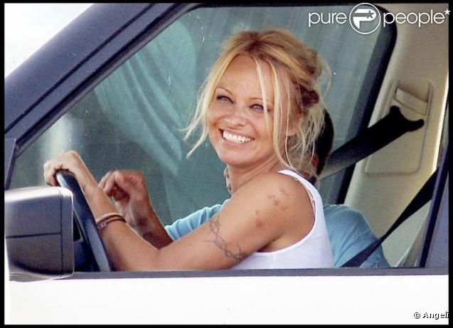 Pamela Anderson sans maquillage, toute souriante au volant de sa voiture le 19 septembre 2009