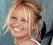 Pamela Anderson sans maquillage, toute souriante au volant de sa voiture le 19 septembre 2009