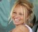 Pamela Anderson sans maquillage, toute souriante au volant de sa voiture le 19 septembre 2009