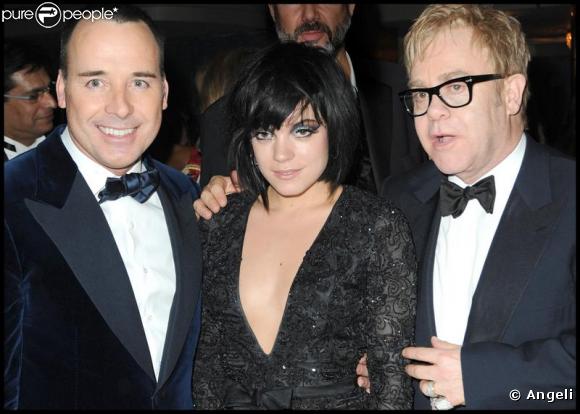 David Furnish et Elton John entourent une Lily Allen, très décolletée lors de la soirée de gala Grey Goose Vodka  - character &amp; cocktails - à Londres, au profit de la fondation Elton John le 23 décembre 2009