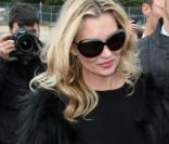Kate Moss en total look black pour le défilé Dior. Jupe en cuir droite, escarpins pointus, lunettes XXL, le look de star hollywoodienne est assuré. 
