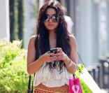 Vanessa Hudgens en mode bohême avec un top blanc et une jupe longue très gipsy aux imprimés rouges et oranges. 