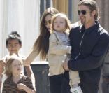 Angelina Jolie et Brad Pitt qui porte dans ses bras Knox, en mars 2011 à la Nouvelle Orléans. En arrière plan, Shiloh et Maddox 
