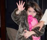 Suri Cruise fait coucou aux photographes en compagnie de sa maman Katie Holmes et Tom Cruise à New York le 20 décembre 2011
