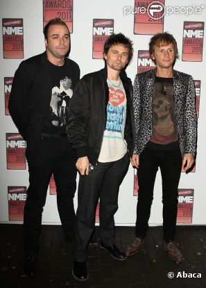 Christopher Wolstenholme (à gauche) en février 2011 en compagnie de Matthew Bellamy et de Dominic Howard (à droite)