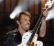Johnny Hallyday et la fameuse guitare qu'on lui a dérobée, au Stade de France, le 15 juin 2012.