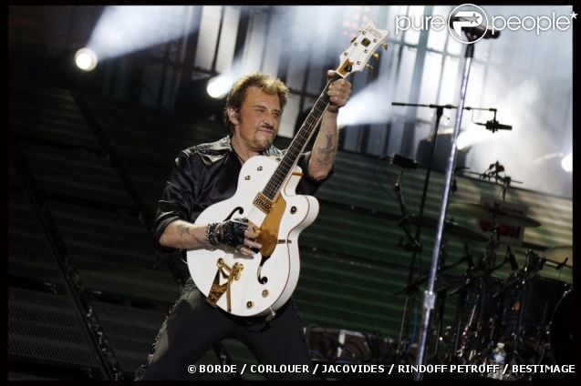 Johnny Hallyday et la fameuse guitare qu'on lui a dérobée, au Stade de France, le 15 juin 2012.