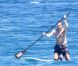 L'ancien ministre Eric Besson se laisse tenter par le paddle surfing au large de Saint-Tropez, le 12 juillet 2012.
