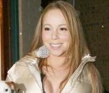 La chanteuse Mariah Carey, dans un style plus chic, porte une jolie doudoune beige nacrée ceinturée à la taille.