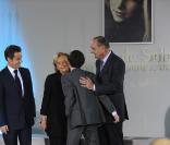Bernadette Chirac reçoit les insignes de chevalier de la Légion d'honneur des mains du président Nicolas Sarkozy, le 18 mars 2009 à la Maison de Solenn. Son petit-fils, Martin, vient sur l'estrade pour la féliciter. 