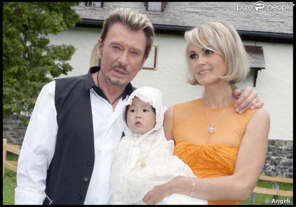 Johnny et Laeticia Hallyday avec Joy au cours du baptême de cette dernière à Gstaad en Suisse le 5 juillet 2009