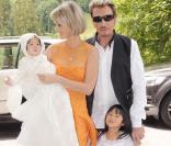 Johnny et Laeticia Hallyday avec leurs filles Jade et Joy au cours du baptême de cette dernière à Gstaad en Suisse le 5 juillet 2009