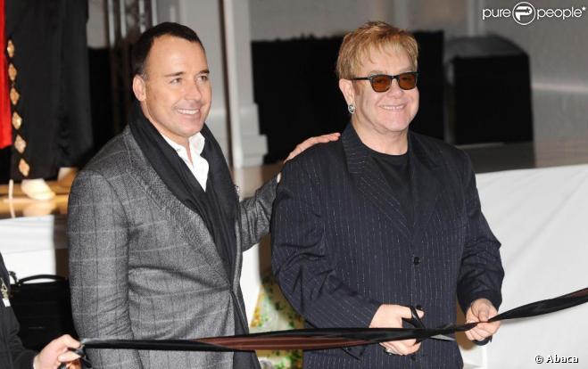 Elton John et son mari David Furnish, le 11 décembre à Londres, lors de l'inauguration de la vente de vêtements et accessoires du chanteur au profit de son association de lutte contre le Sida.